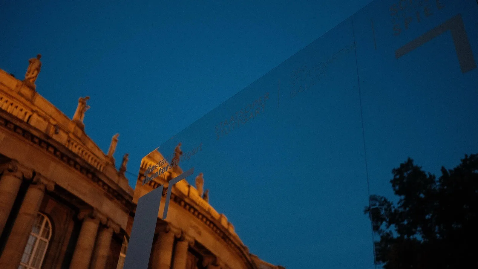 Der Info-Pavillon vor der Staatsoper Stuttgart, Schriftzug gegen den blauen Abendhimmel